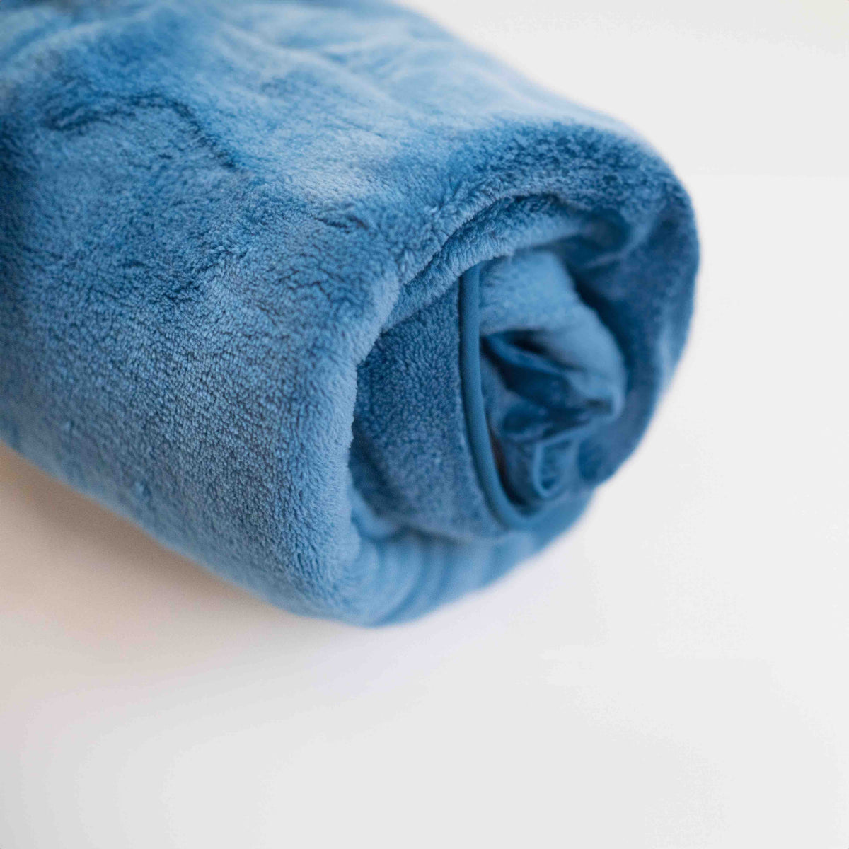The blue Ocean Breeze Dog Towel Robe rolled into a compact bundle.