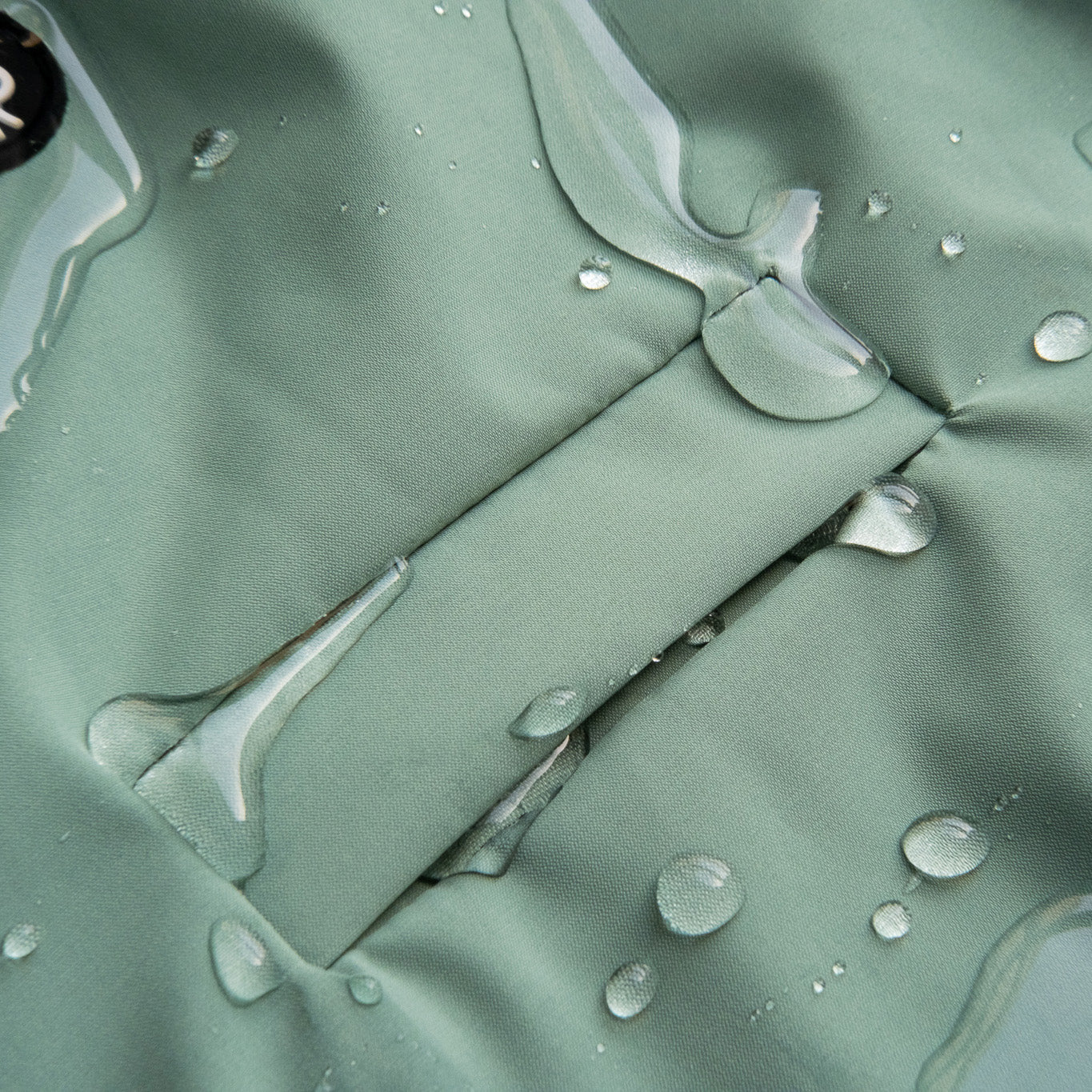 Dog raincoat with water droplets on the fabric, demonstrating its waterproof and protective design for outdoor adventures.